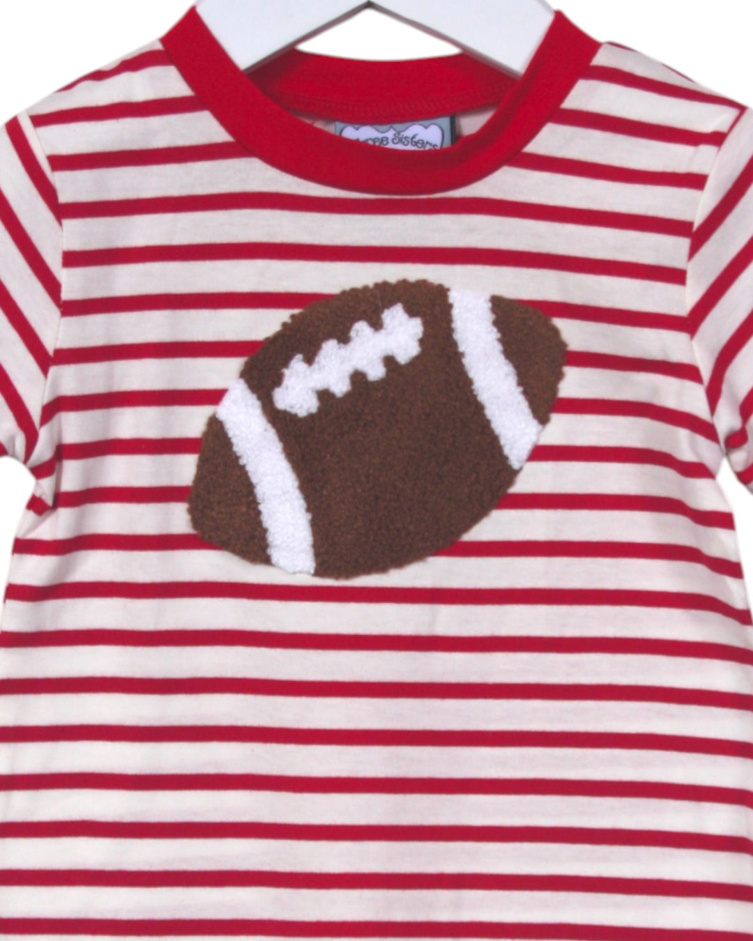 Red and white striped shirt with a brown football design on a hanger.