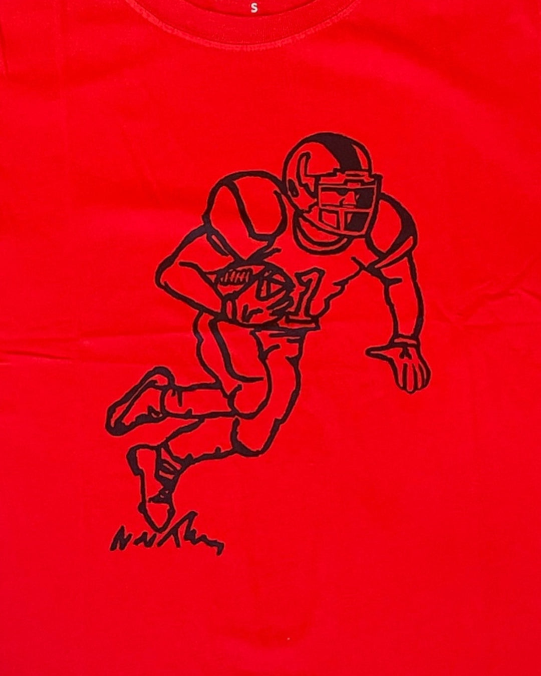 Red t-shirt with black outline of a football player and ball on a red background