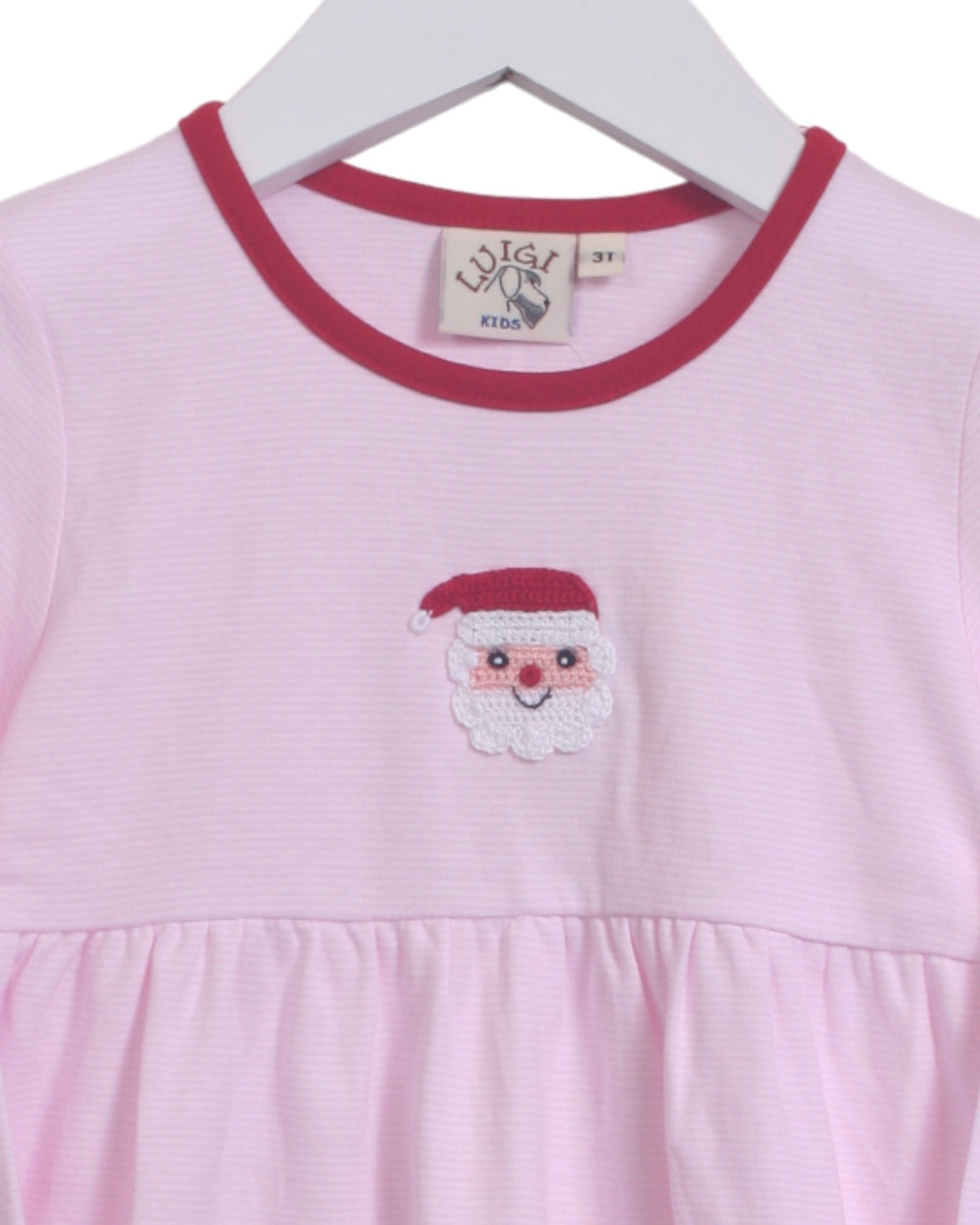 Pink dress with Santa face design on a hanger
