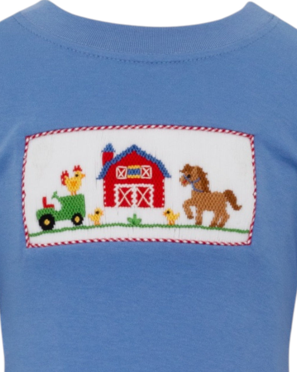Blue shirt with a farm-themed patch featuring a barn, tractor, and animals.