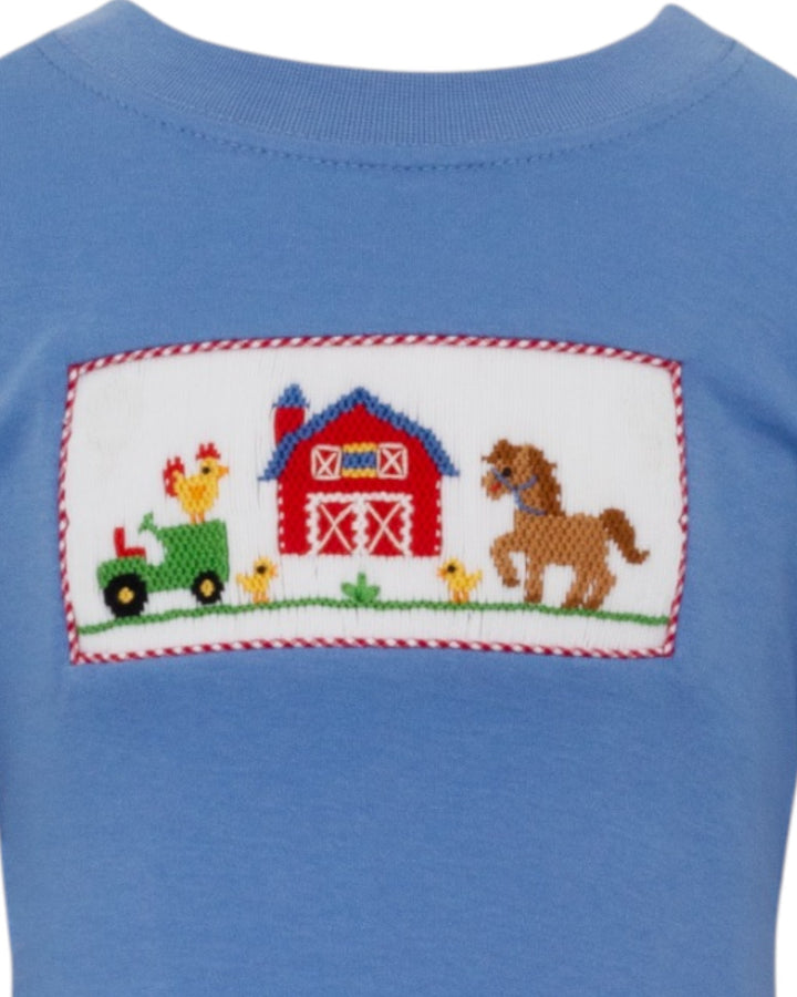 Blue shirt with a farm-themed patch featuring a barn, tractor, and animals.