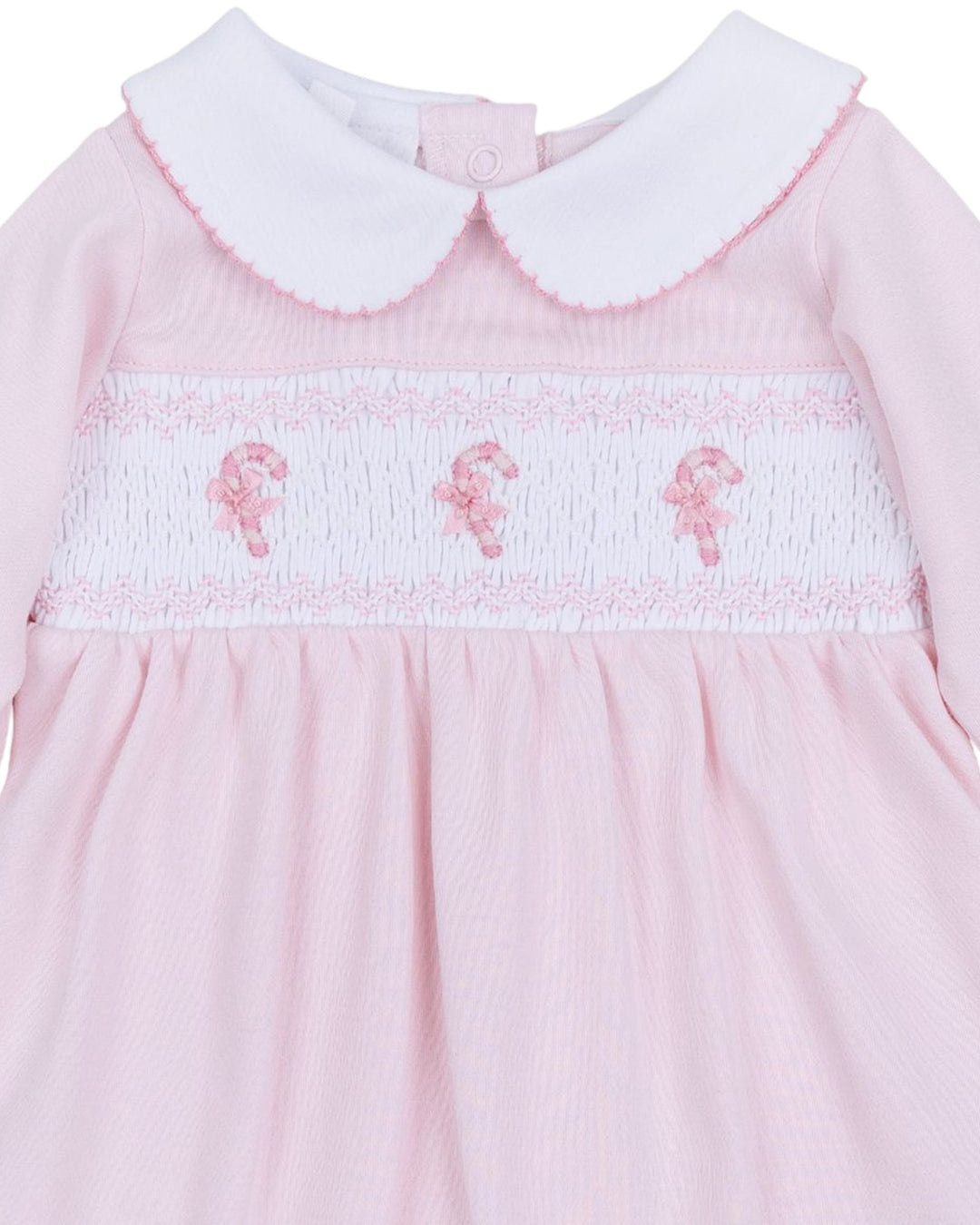 Pink dress with white collar and embroidered details on a white background