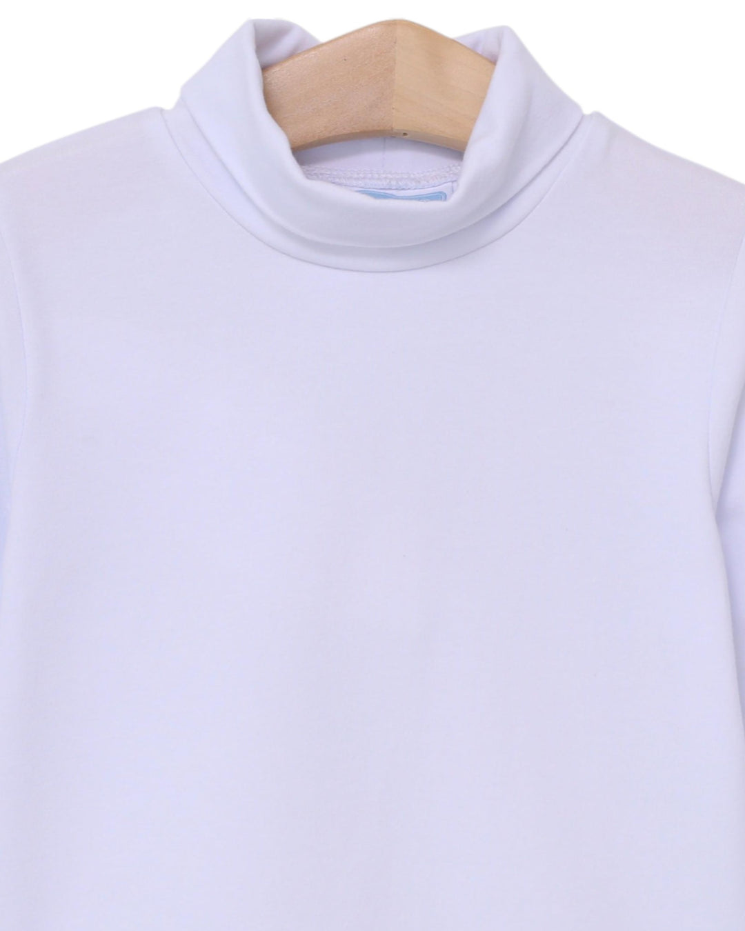 Light white turtleneck shirt on a wooden hanger against a white background