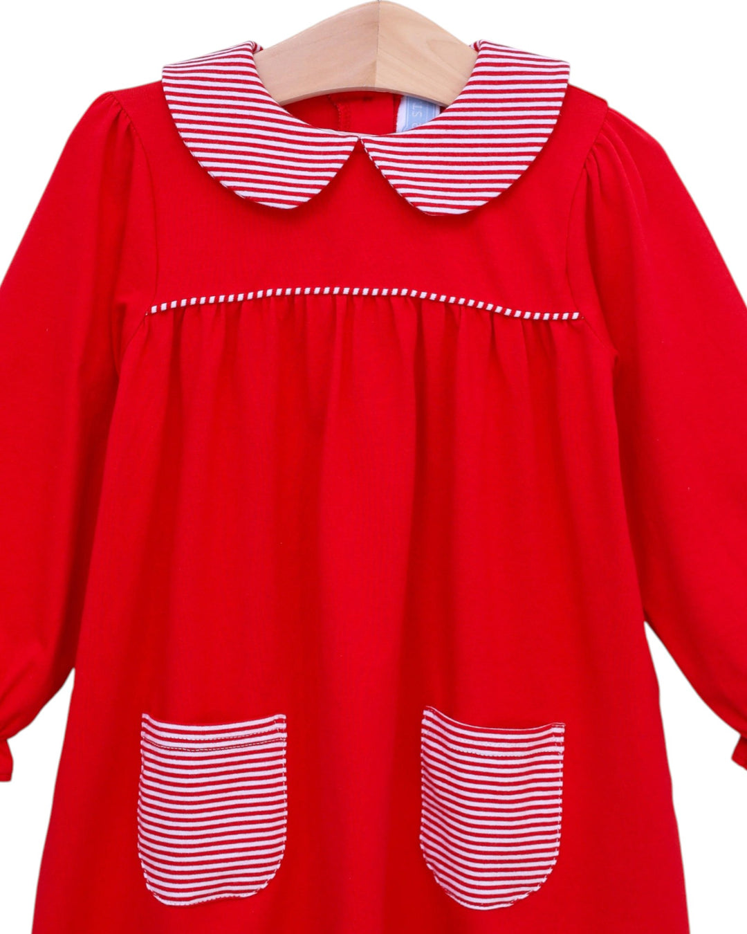 Red dress with white striped collar and pockets on a hanger