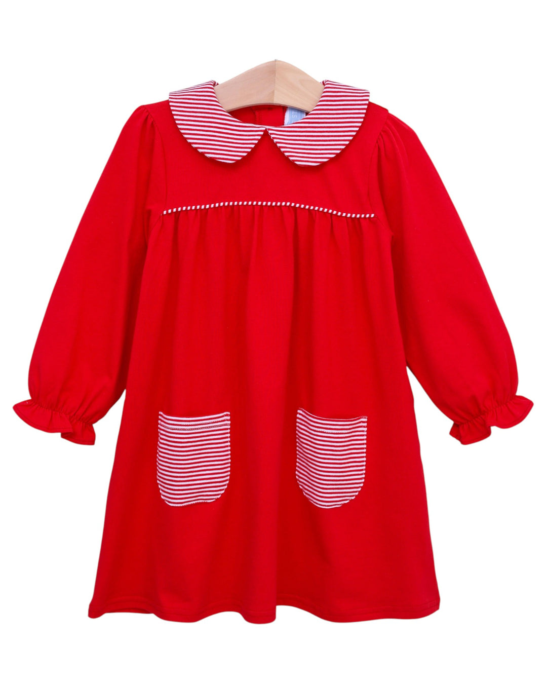 Red dress with white trim on a hanger against a white background