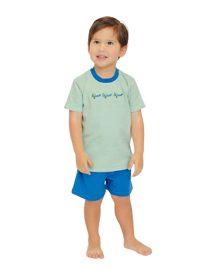 Child wearing a green striped shirt and blue shorts on a white background