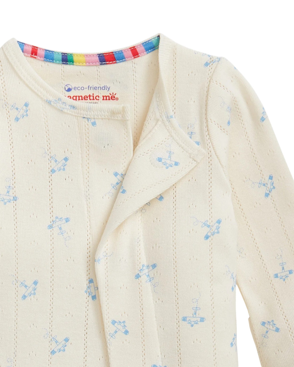 Close-up of a baby outfit with floral pattern and colorful trim, featuring the brand 'magnetic me'.