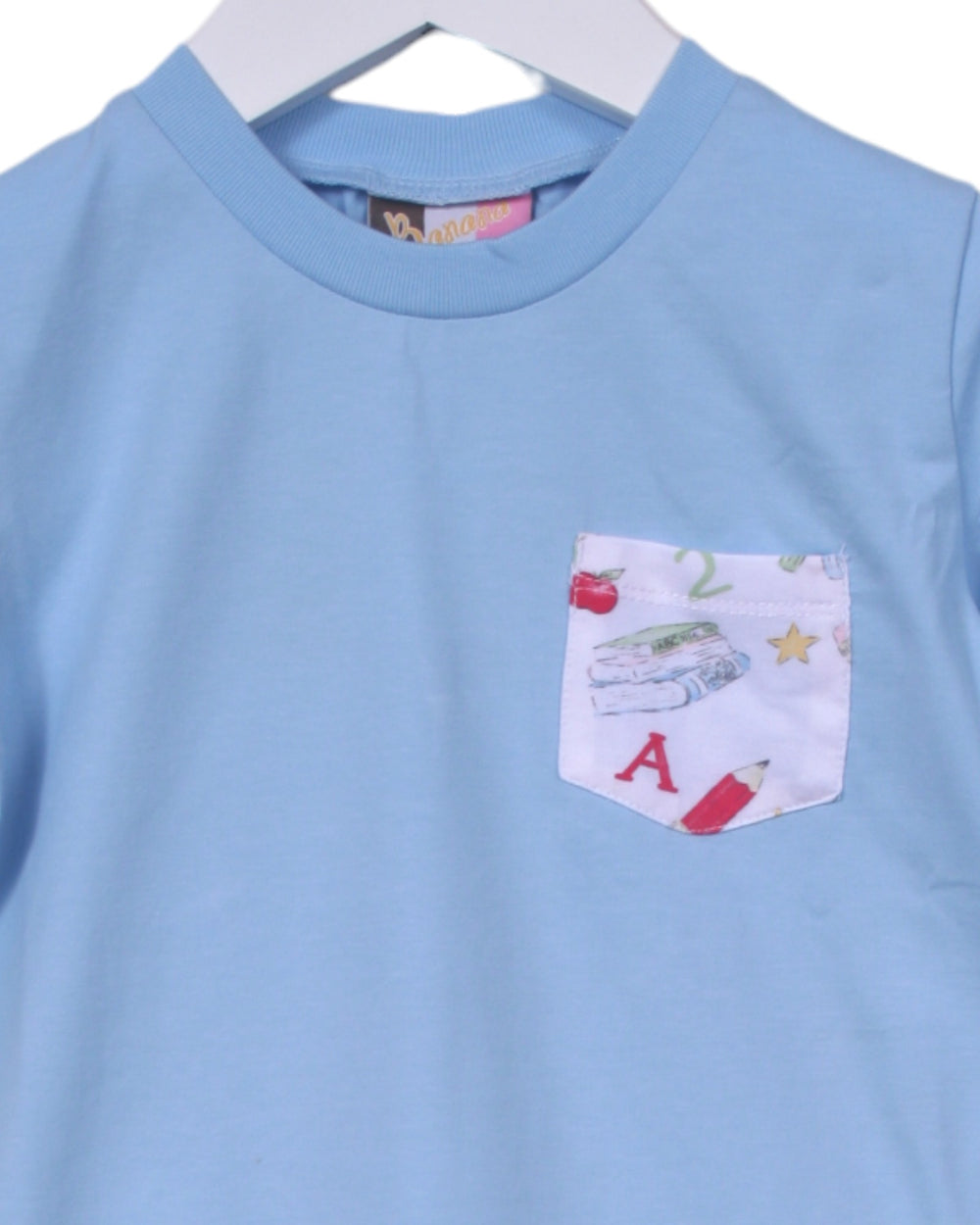 Light blue shirt with a pocket featuring educational-themed design on a white background