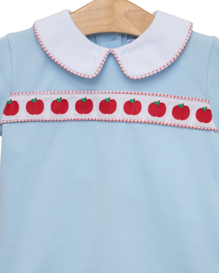 Light blue dress with red apple pattern on a hanger