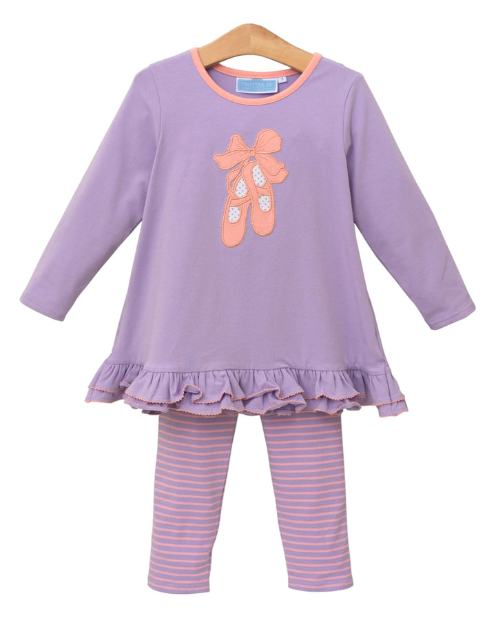 Children's outfit with purple top and striped pants on a white background
