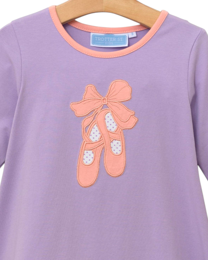 Purple shirt with pink ballet shoes and bow design on a hanger