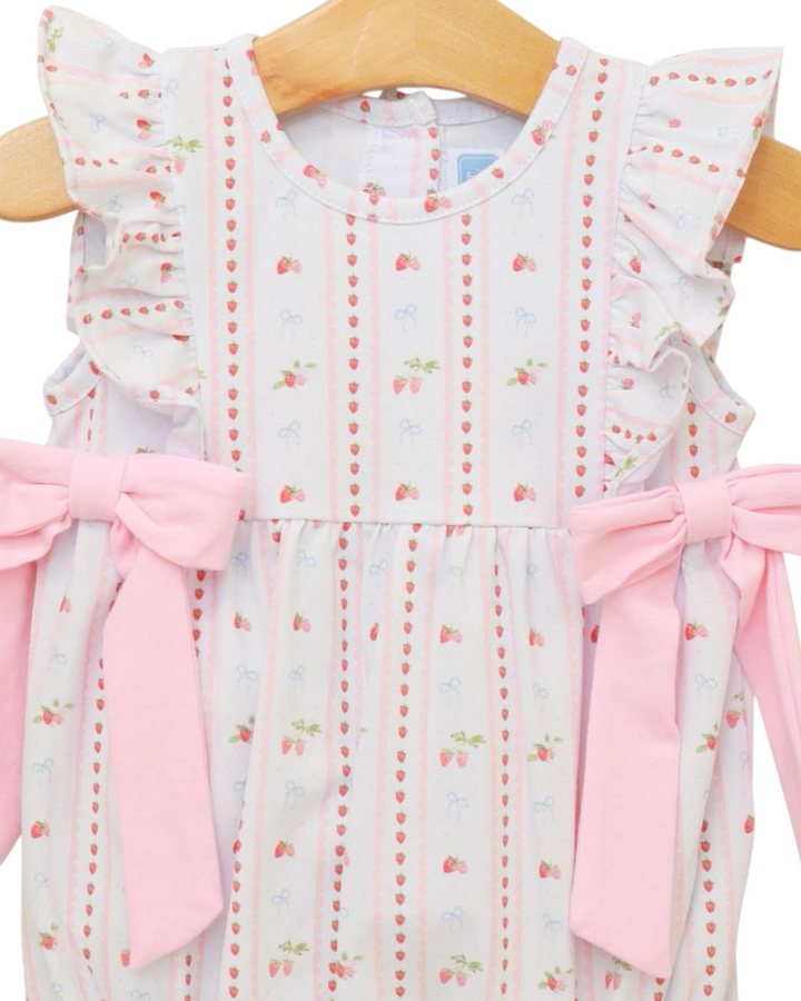 Children's dress with ruffled sleeves and pink bows on a hanger