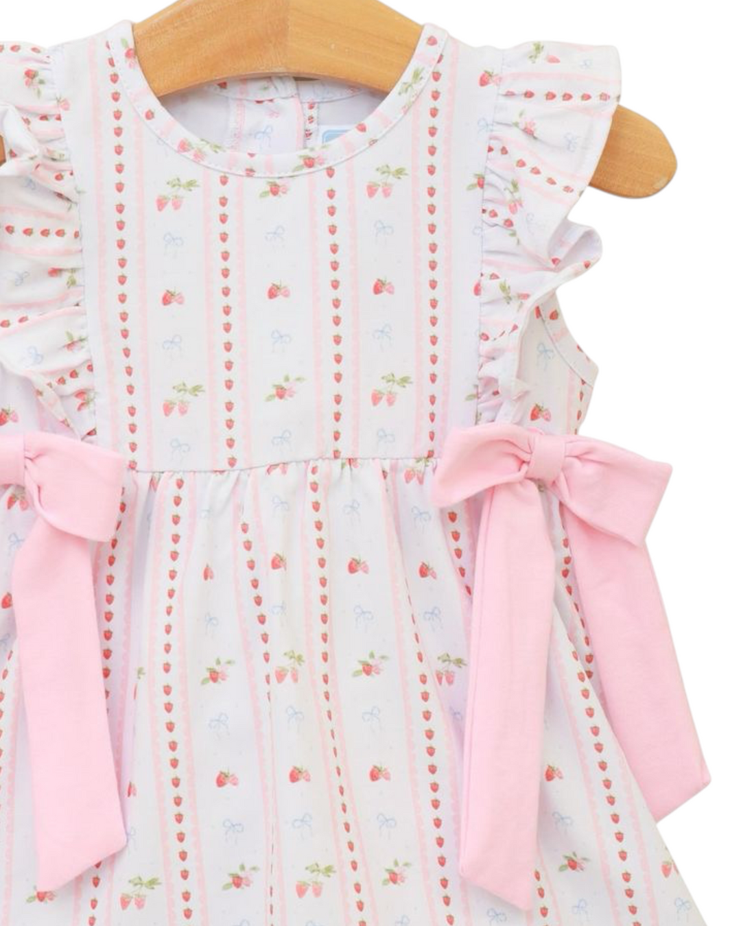 Baby dress with floral pattern and pink bows on a hanger