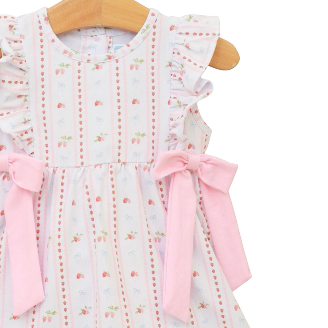 Baby dress with floral pattern and pink bows on a hanger