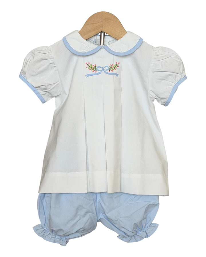 White baby dress with blue trim and matching bloomers on a hanger against a white background, that store 