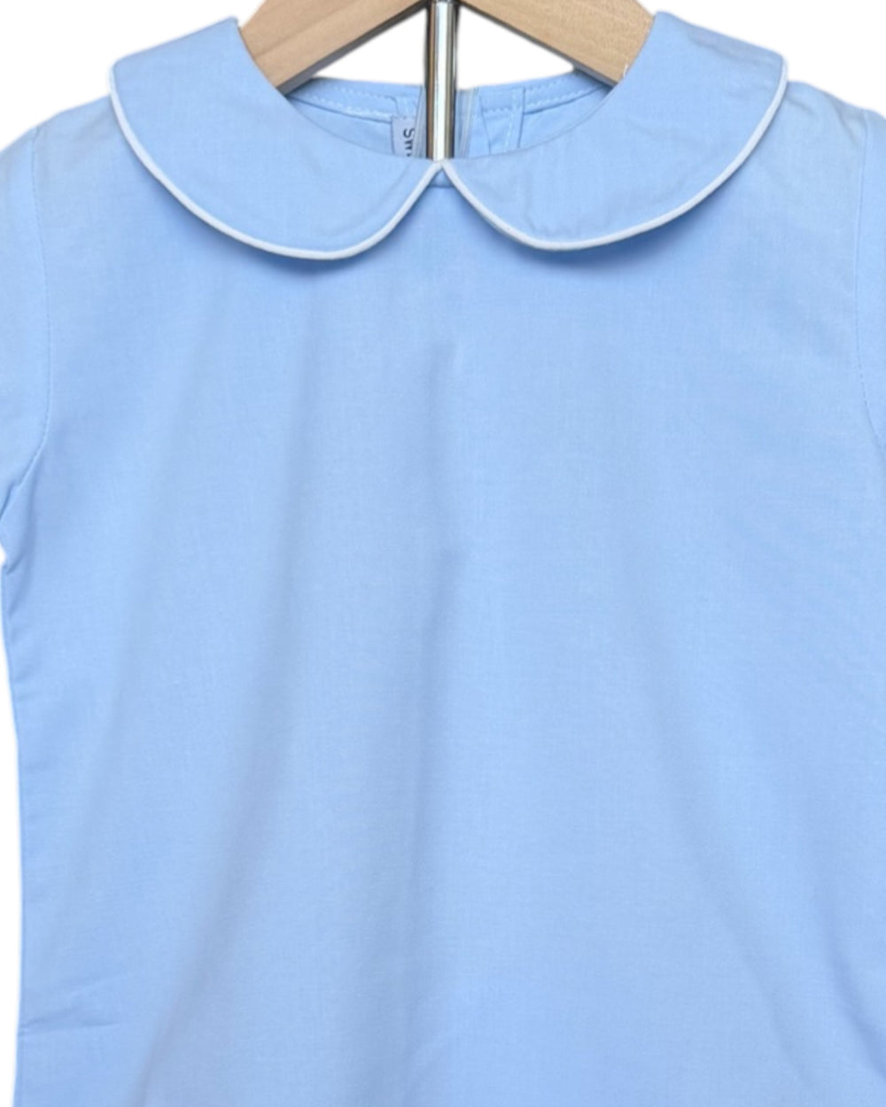Light blue shirt with a white collar on a hanger