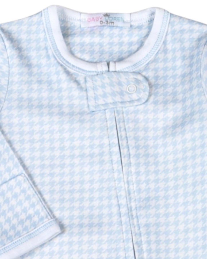 A close-up of a baby sleep sack featuring a light blue and white houndstooth pattern, with a snap-button closure at the collar, that store