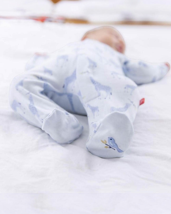 Baby wearing white socks with bird accents on a white blanket