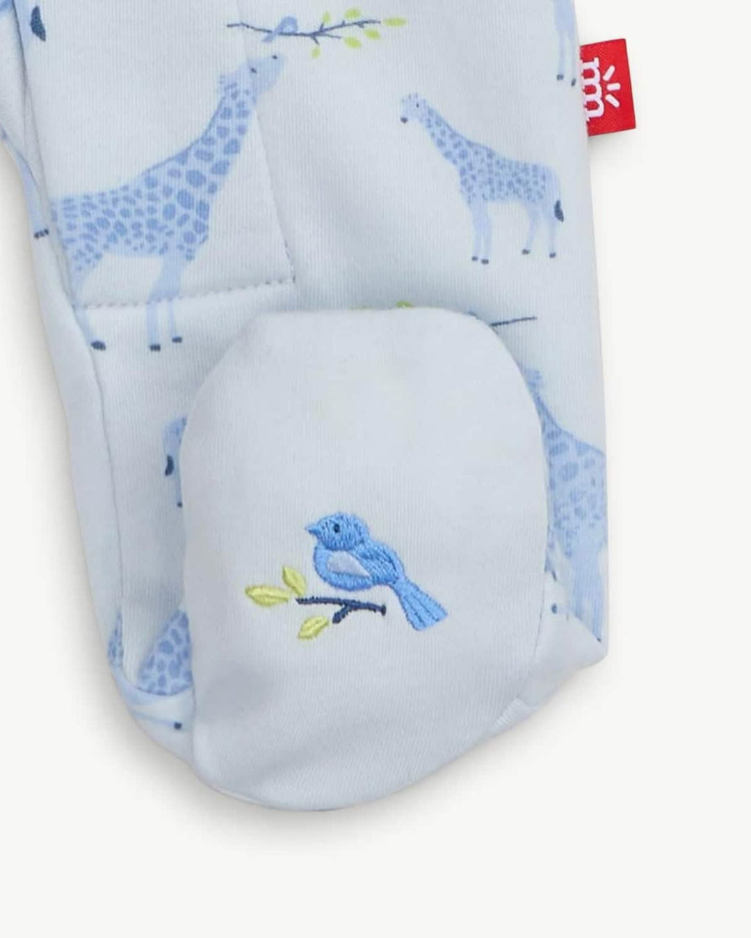 Baby romper with blue giraffe pattern and embroidered bird on a white background