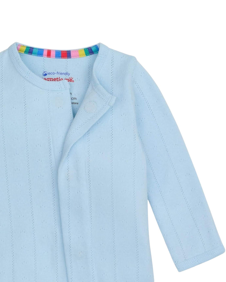 Light blue baby cardigan with rainbow trim on a white background