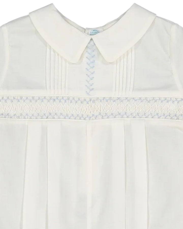 White dress with a smocked collar and trim on a white background