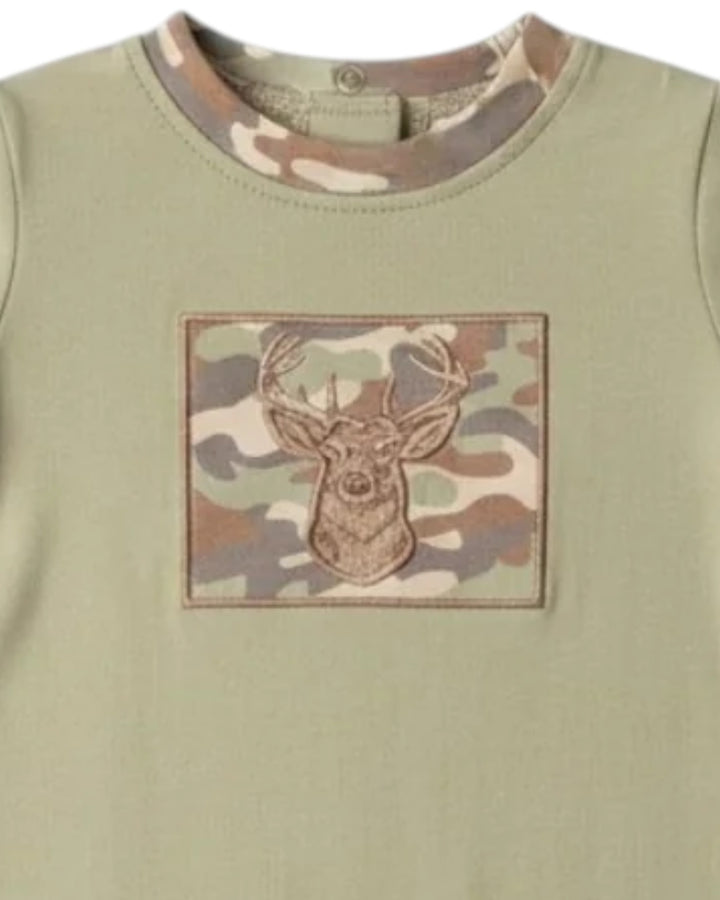 A close-up of a sage green long-sleeve shirt featuring a square camouflage patch on the chest with an embroidered deer head motif, that store
