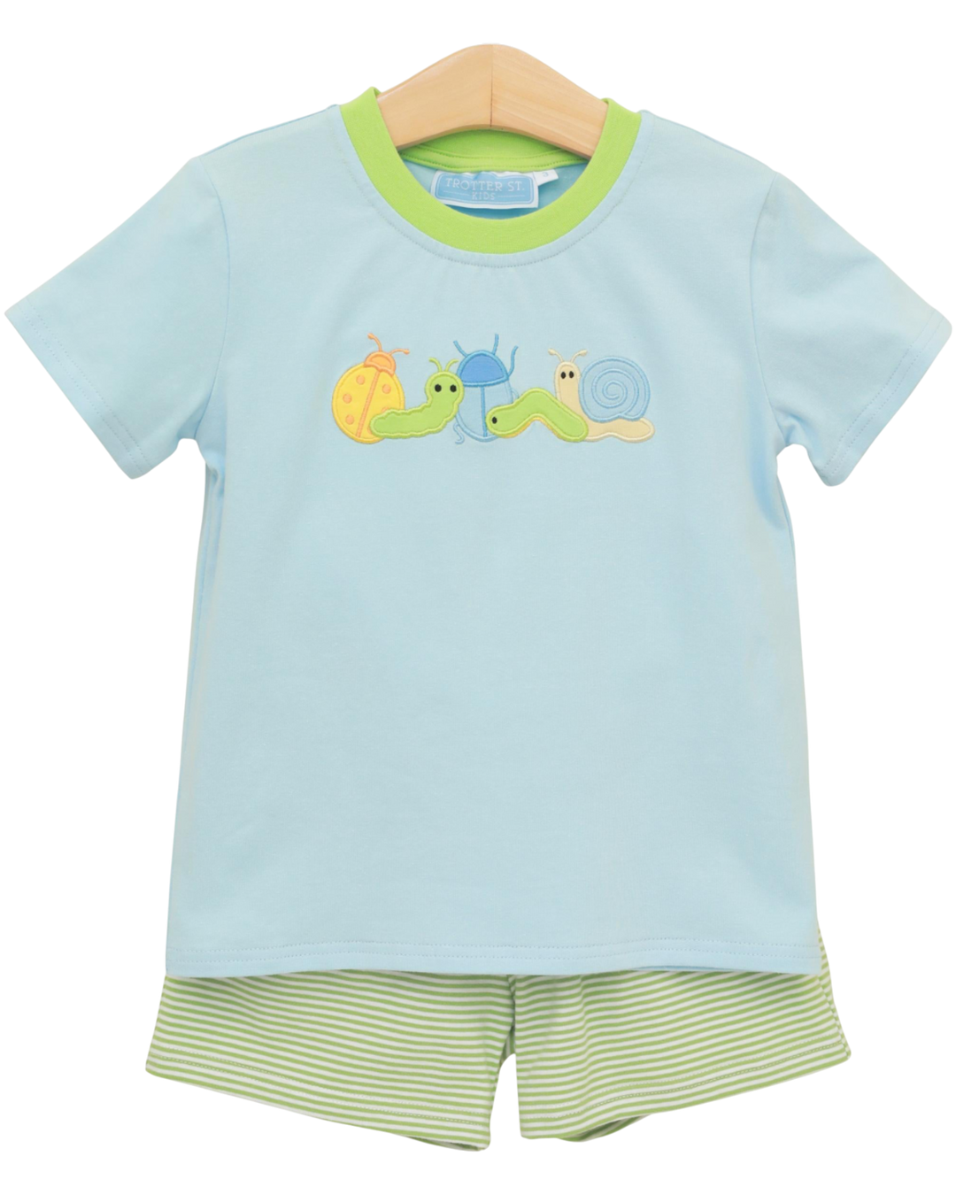 Children's light blue shirt with snail design and green shorts on a white background
