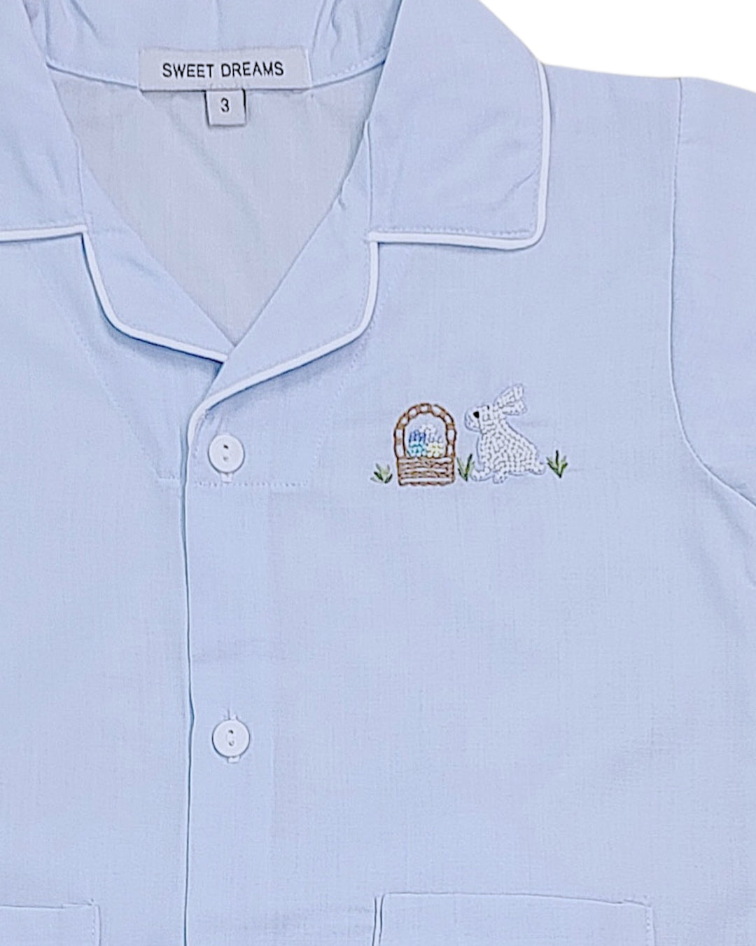 Light blue pajama top with embroidered design and 'Sweet Dreams' label.
