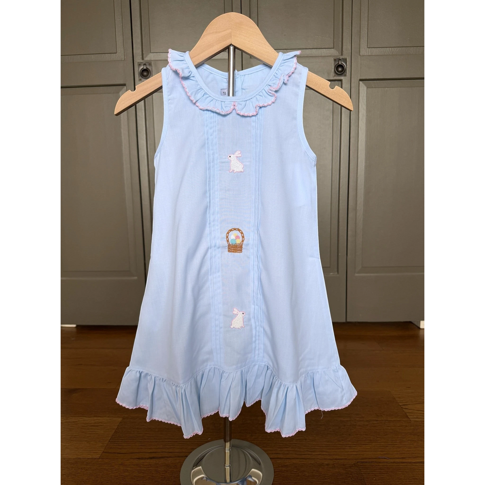 Light blue dress with bunny and carrot design on a wooden hanger against a neutral background
