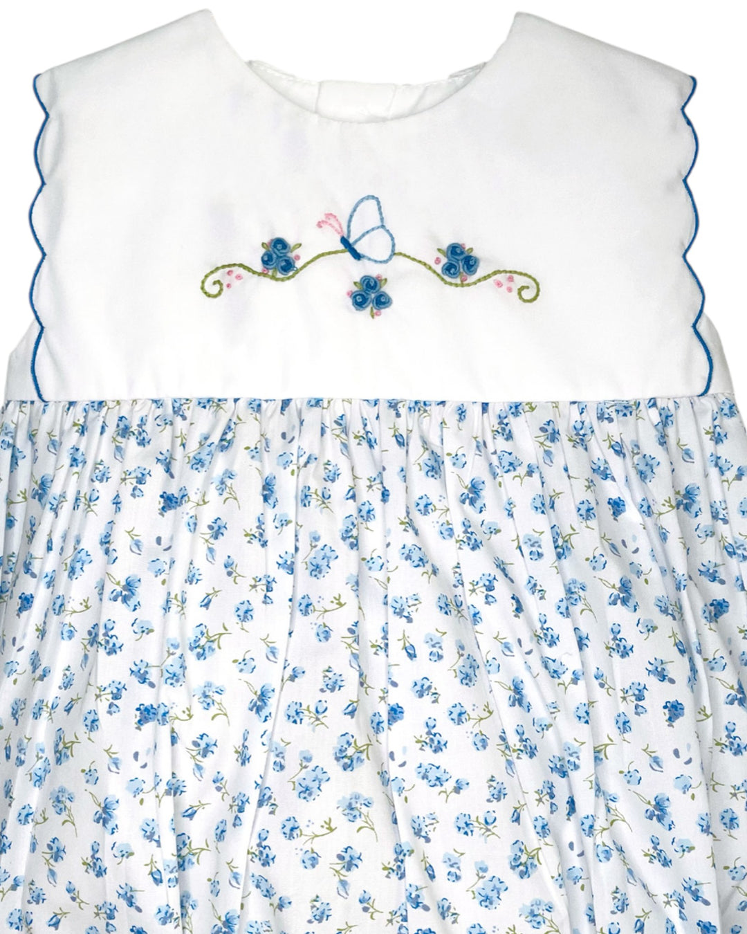 White dress with blue floral pattern and embroidery on a white background
