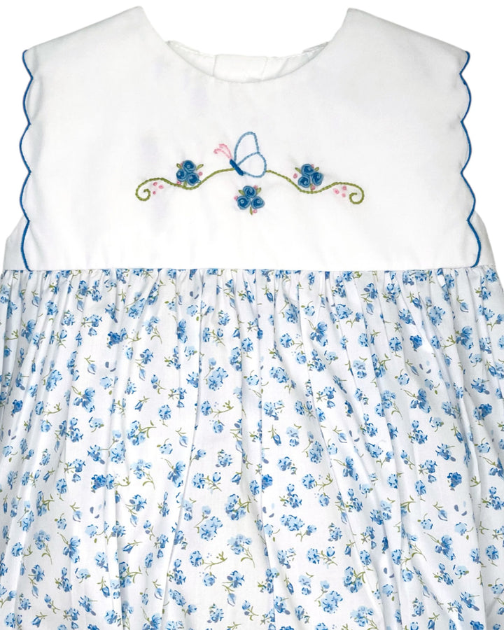 White dress with blue floral pattern and embroidery on a white background