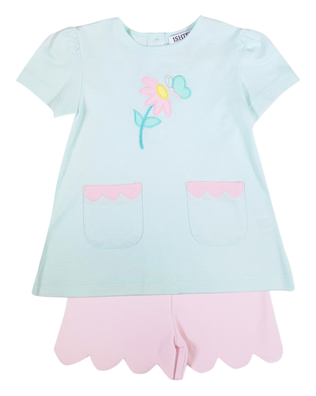 Light blue t-shirt with a colorful flower design and pink shorts on a white background