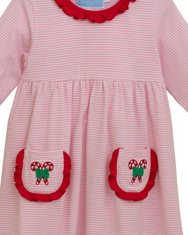 Pink striped dress with red trim and candy cane pockets on a white background