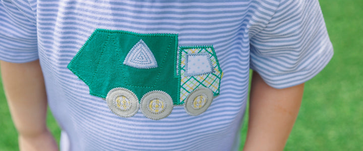 Children's shirt with a green truck design on a grassy background