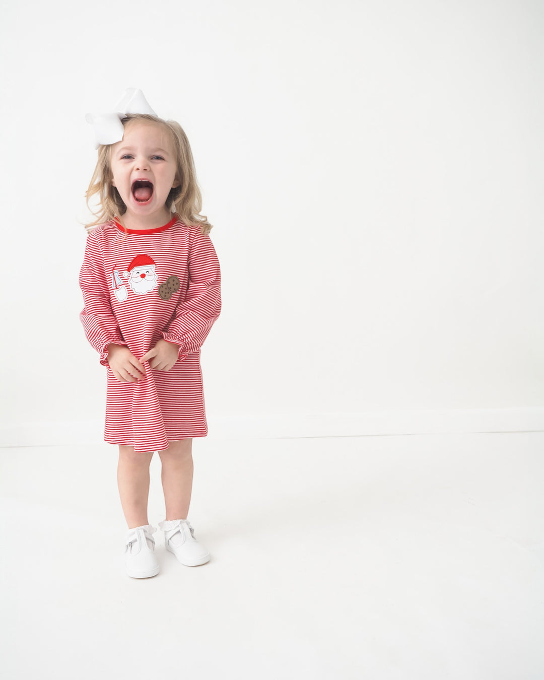 Child wearing a red and white striped dress with a graphic on a white background