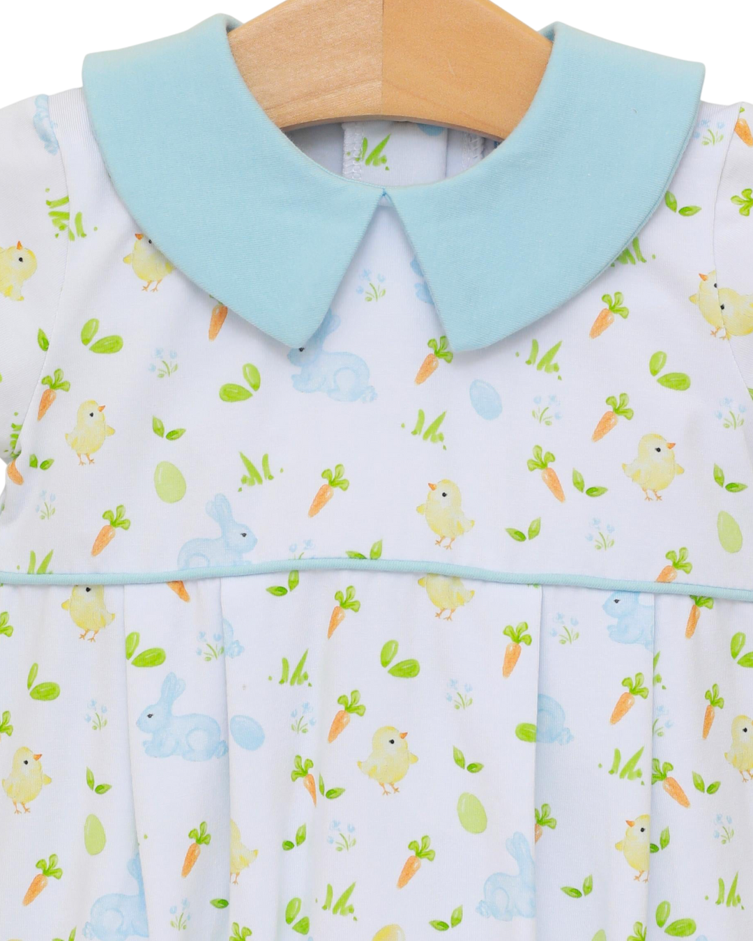 Baby bib with a light blue collar and animal pattern on a hanger