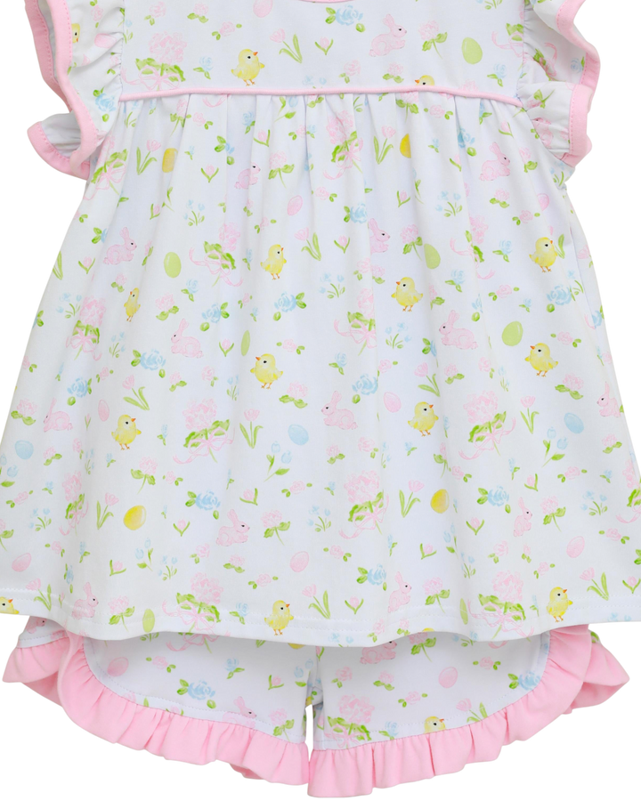 Children's outfit with floral pattern and pink ruffles on a white background