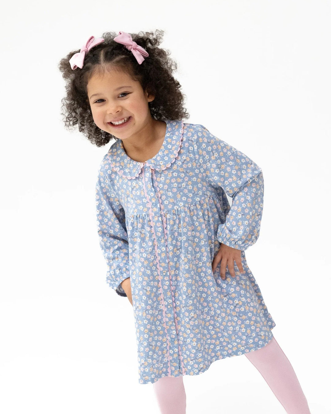 Young girl wearing a blue floral nightgown on a white background