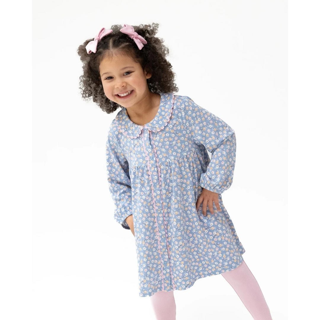 Young girl wearing a blue floral nightgown on a white background