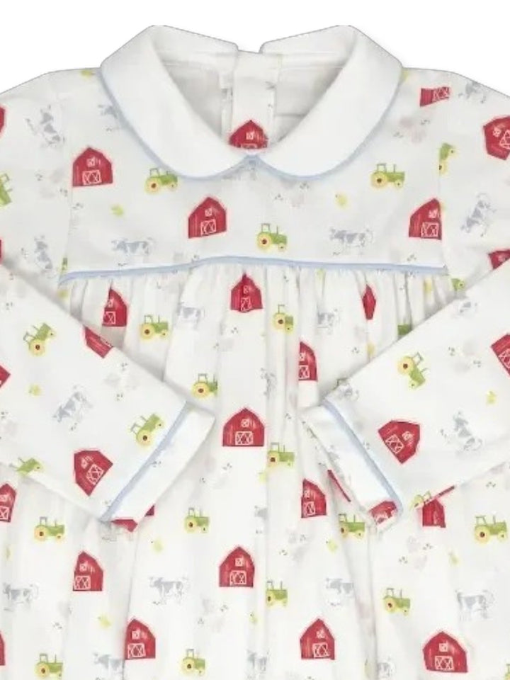 A long-sleeve baby nightgown with a white base, featuring a colorful print of red barns, green tractors, and small yellow sunflowers, finished with a white Peter Pan collar and light blue piping, that store