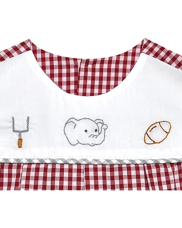 Children's apron with checkered trim and embroidered designs on a white background