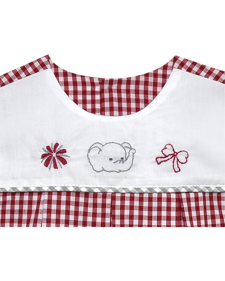 Embroidered bib with checkered red and white trim on a white background