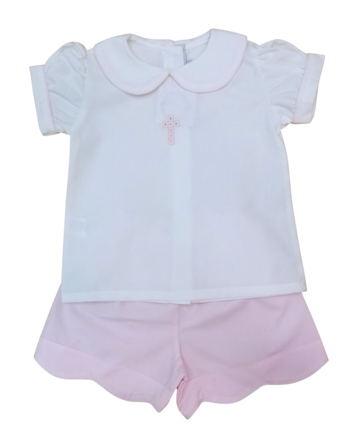 Children's outfit with white top and pink shorts on a white background