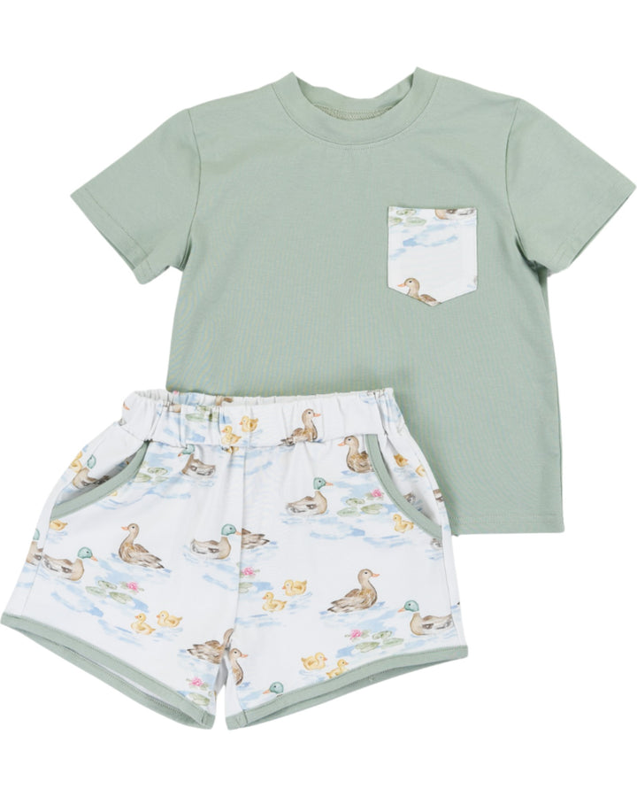 Children's outfit with a green t-shirt and duck-patterned shorts on a white background