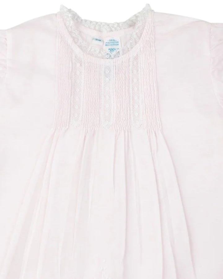 Close-up of a light pink garment with a subtle pattern on a white background