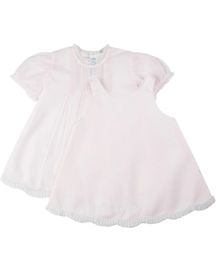 Pink baby dress with ruffled hem on a white background