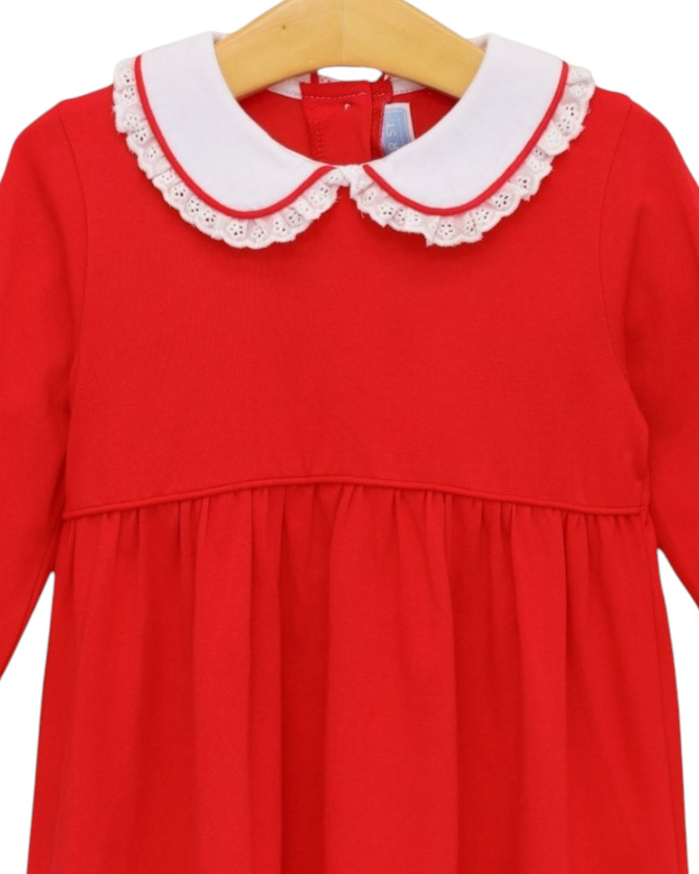 A bright red long-sleeve dress with a white eyelet Peter Pan collar, hanging on a wooden hanger against a white background, that store