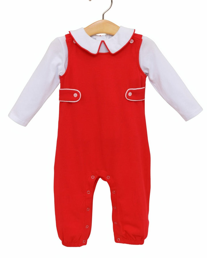 A baby red overall jumpsuit with a white long-sleeve shirt underneath, displayed on a wooden hanger against a plain white background, that store