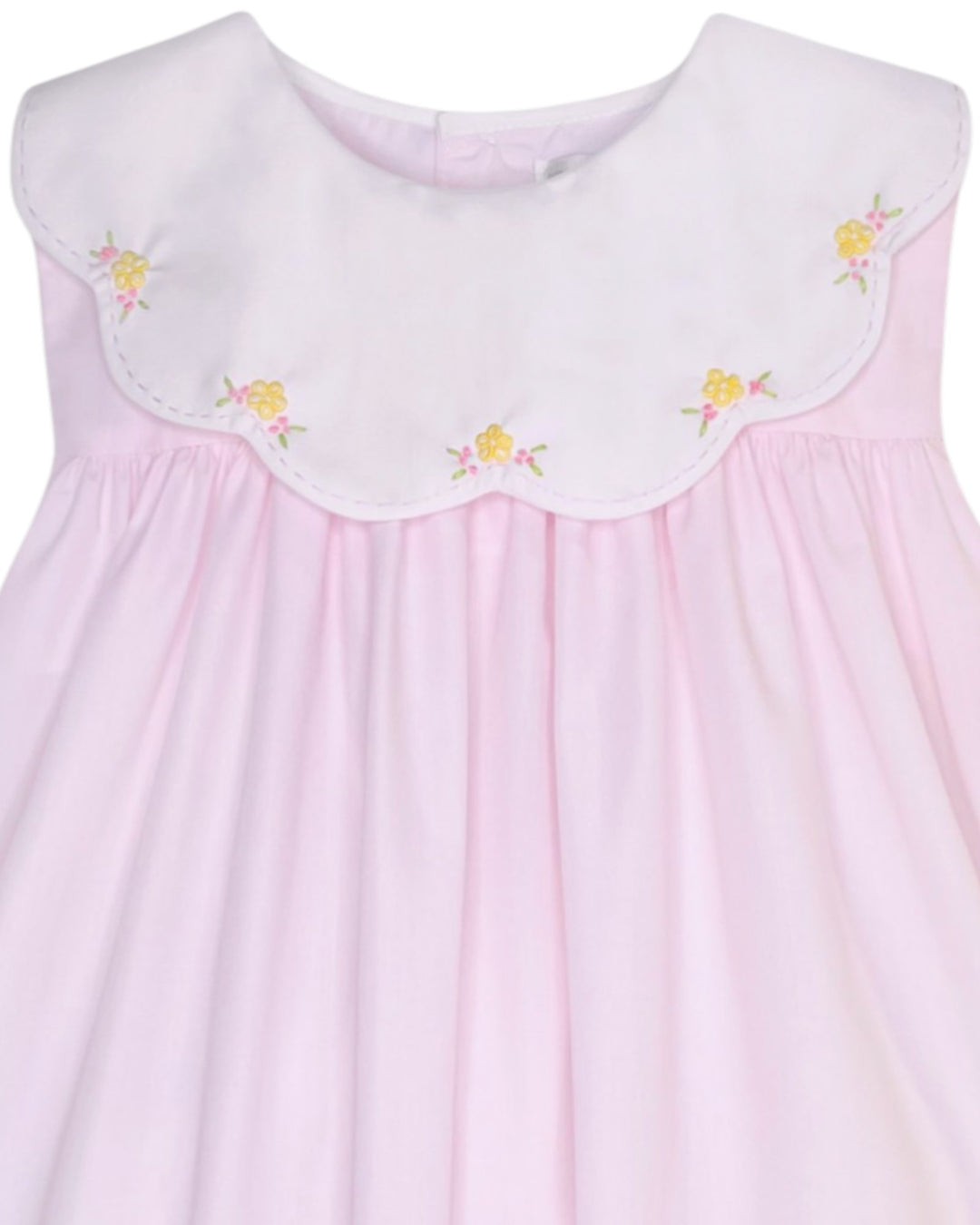 Pink dress with floral embroidery on a white background