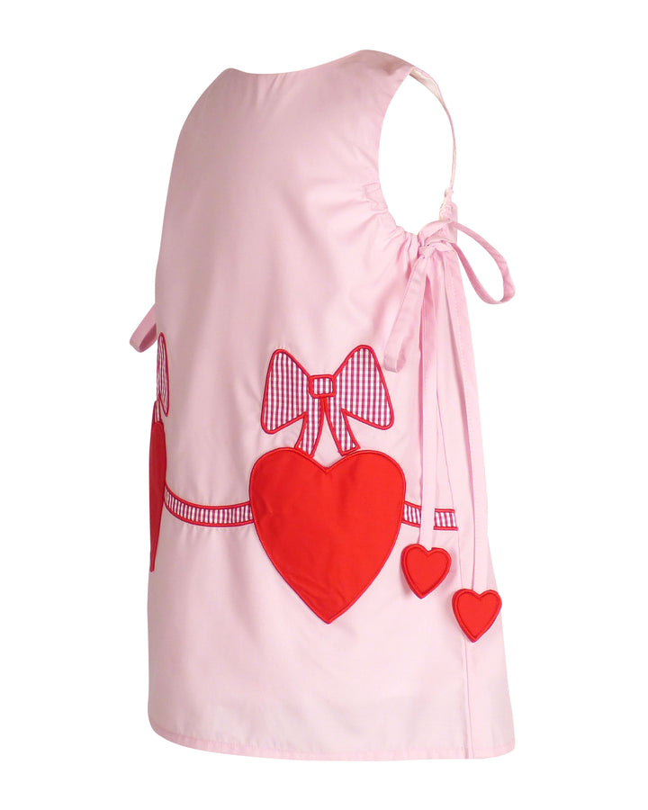 Pink dress with red hearts and bows on a white background